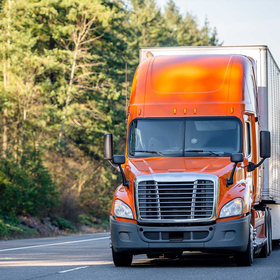 orange_semi_truck_driving_down_road