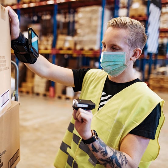 Warehouse worker scanning box with handheld scanner
