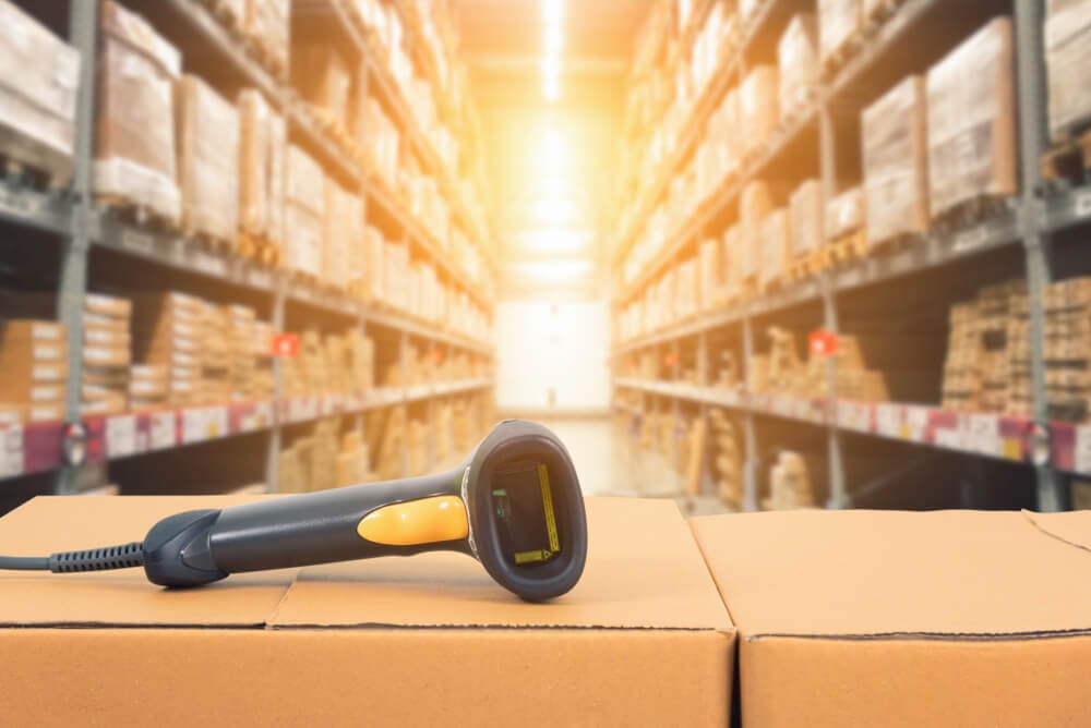 Barcoding scanner sitting on a cardboard box in a warehouse