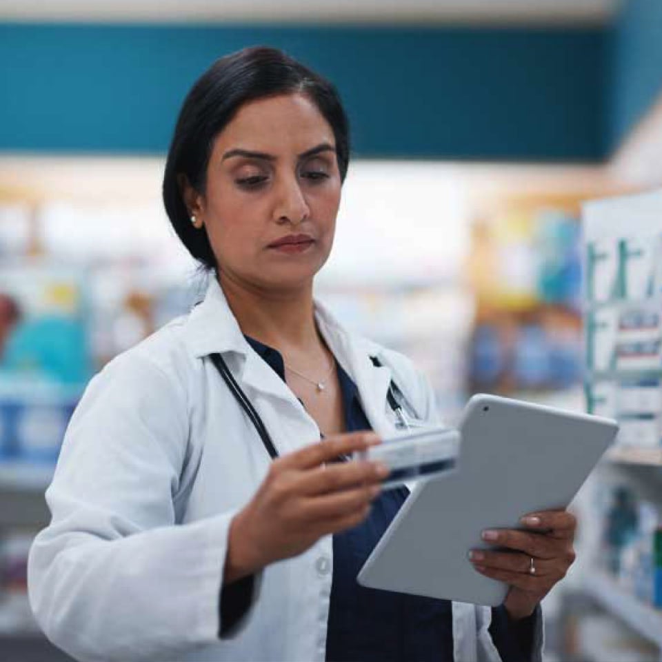 female medical person with ipad looing at packaging