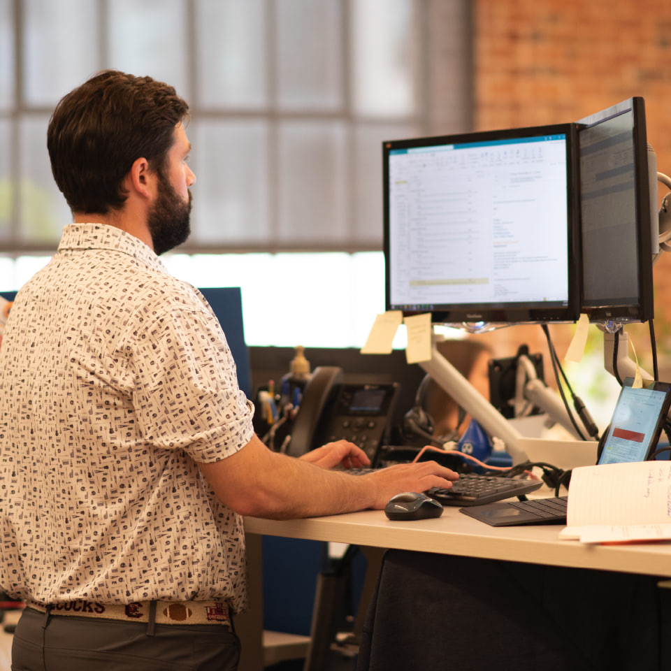 man standing in front of computer terminal