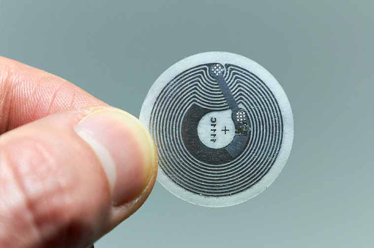 RFID tag chip being held by fingers