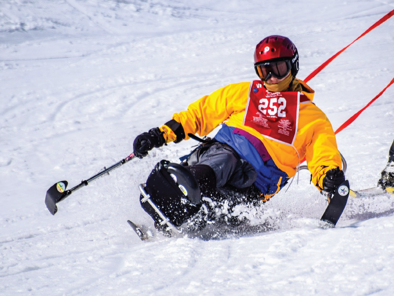 Disabled person skiing down a snow covered hill