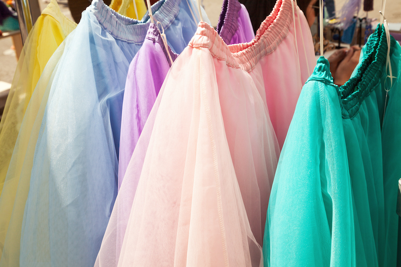 Tops in different colors hanging on a rack