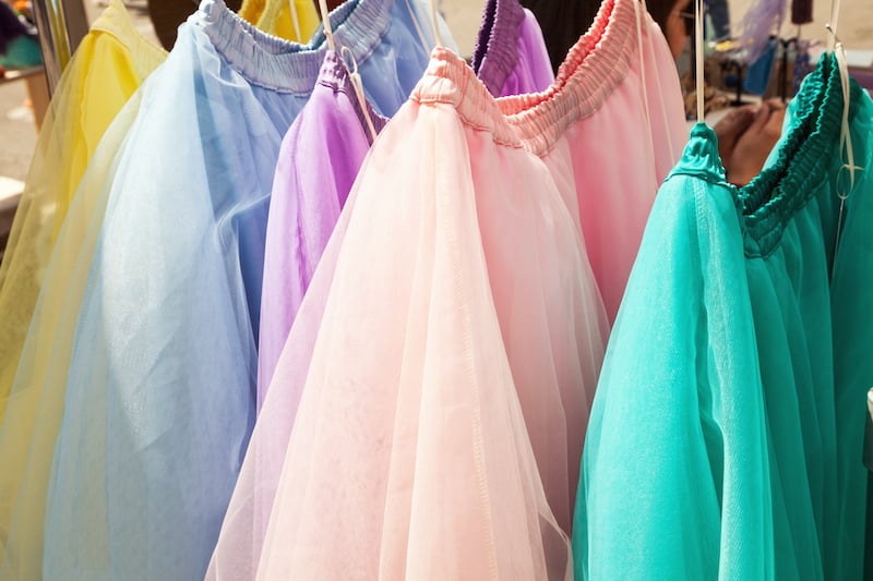 Tops in different colors hanging on a rack